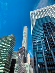 Fototapeta premium Tall Glass Skyscrapers in Manhattan Against a Blue Sky