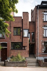 The contemporary brick facade of an urban building prominently features various architectural design elements, beautifully illuminated by the daylight in a bustling city environment
