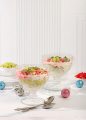 Christmas and New Year's dishes. Kiwi and pomegranate parfait on a bright festive table, an idea for decorating food and decorating New Year's dishes. Banner for the screen ,template for creativity