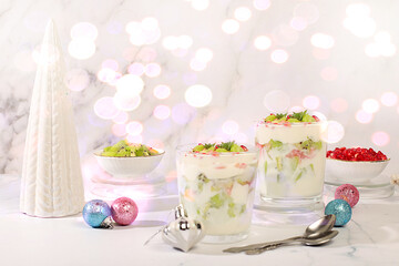 Kiwi and pomegranate parfait on a bright festive table, an idea for decorating food and decorating New Year's dishes. Christmas and New Year's dishes. Banner for the screen , template for creativity
