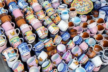 A display of colorful mugs with one that says 