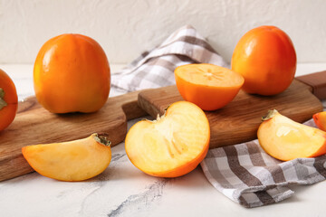 Wooden boards with sweet ripe persimmons on white background