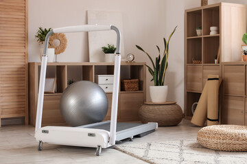 Modern treadmill in interior of cozy living room