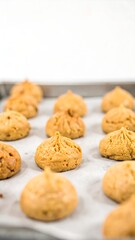 Baked, light brown, small, puffy cookies on a baking sheet