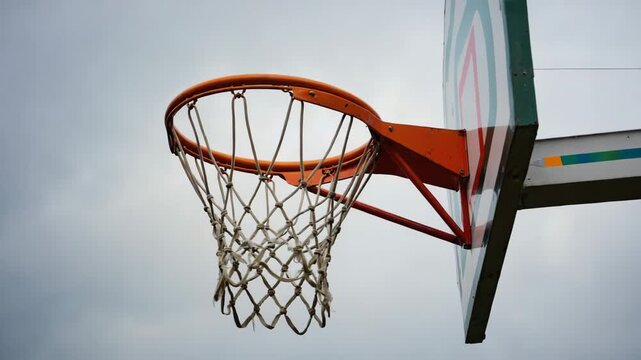 Leerer Basketballkorb im Freien unter wolkigem Himmel