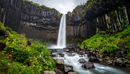 Majestic waterfall cascading down basalt cliffs. Lush greenery surrounds the base