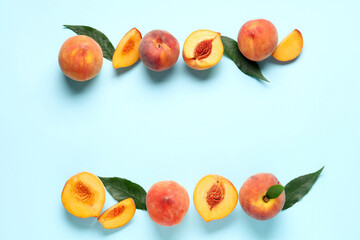 Sweet ripe peaches and leaves on blue background