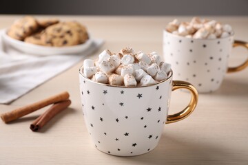 Cup of hot drink with marshmallows on wooden table,