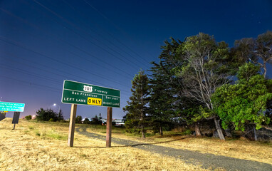 A U.S. Route 101 freeway sign near San Francisco International Airport (SFO) in California, USA. The illuminated sign gives directions to San Francisco and San Jose