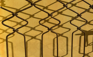 Abstract metal shadow pattern on yellow wall