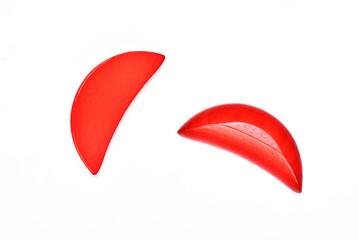 Red wooden divination blocks on white background,When one block lands flat and the other lands curved side up, it is called Sheng Bei. This means the god says “yes” to your question