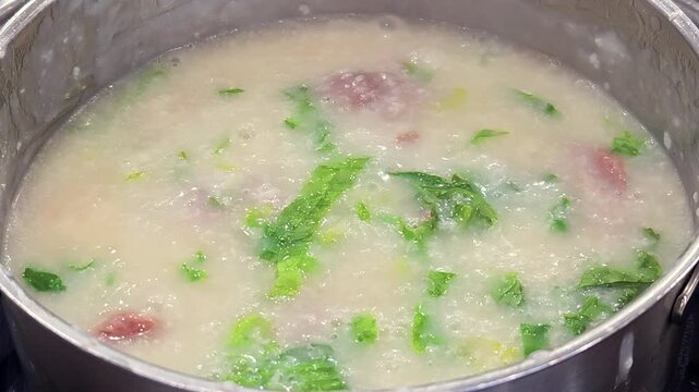cooking Cantonese congee with meat and vegetables in pot