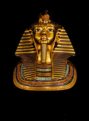 Magnificent Golden Funerary Mask of a Pharaoh Adorned with Hieroglyphs and Precious Stones on a Black Background Showcasing Ancient Egyptian Artistry and Royal Burial Traditions	