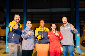 Obraz premium Group of diverse mechanics standing together in workshop showing thumbs up, teamwork in garage small business, partnership and multicultural collaboration reflecting trust in automotive industry