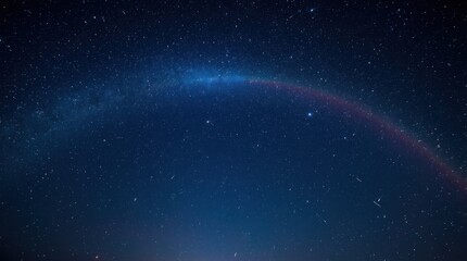Fototapeta premium A stunning night sky showcasing a vibrant rainbow arching over a starry landscape