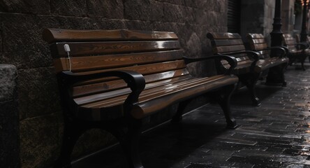 Wooden park benches lined up against a stone wall at night