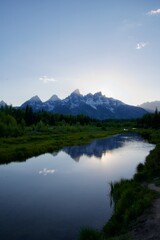 Fototapeta premium mountains are reflected in the water of a river at sunset