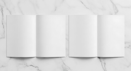 Two open brochures with blank pages, arranged on a marble patterned surface
