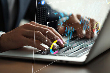 Business professional analyzing data on laptop with digital graphs and charts overlaid, showcasing global statistics and modern technology in the workplace
