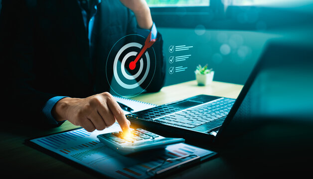 Businessman using calculator with laptop and financial report, target achievement, business planning, budget management, financial analysis, and goal setting strategy concept