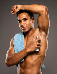 Athletic male model spraying deodorant after shower, fresh and clean energy