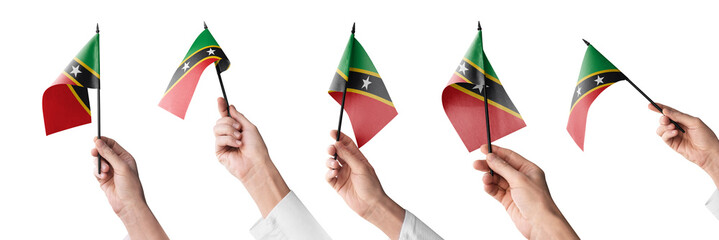 The Saint Kitts and Nevis flag in hand in different angles on a white background