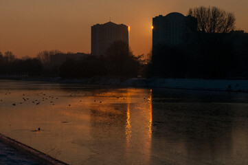 Impression of the rising sun reflecting off apartment buildings along the Watersportbaan in Ghent