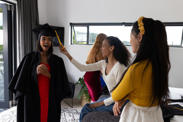Friends celebrating graduation at home, smiling and enjoying special moment together