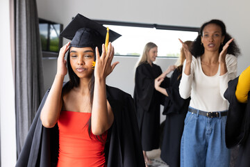 Graduating students in school celebrating academic achievement, adjusting caps joyfully