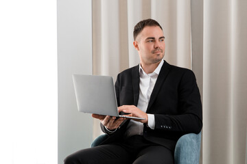 Young businessman is using laptop while sitting in the hotel room