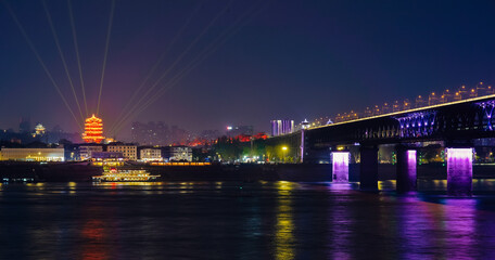 a brilliant night view of Wuhan's Yellow Crane Tower (Huanghelou) and Wuhan Yangtze River Bridge in Hubei, China