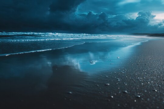 Dark, moody ocean waves crashing against a sandy beach at dusk, creating a dramatic scene under an approaching storm