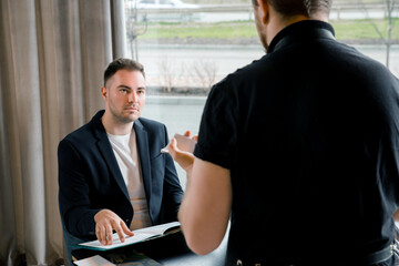 Young man with menu in a restaurant making order