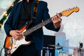Rock band studio rehearsal. Male musician playing bass guitar before live concert