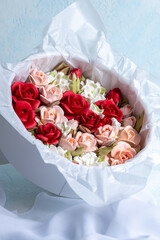 Beautiful arrangement of marshmallow flowers in a white round box, featuring vibrant red, soft pink, and delicate white blooms, showcasing unique floristry concept with copy space