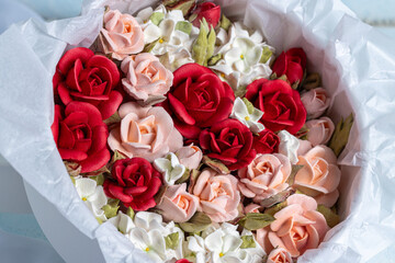 Beautiful arrangement of marshmallow flowers in a white round box, featuring vibrant red, soft pink, and delicate white blooms, showcasing unique floristry concept with copy space