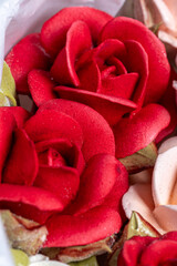 Beautiful arrangement of marshmallow flowers in a white round box, featuring vibrant red, soft pink, and delicate white blooms, showcasing unique floristry concept with copy space
