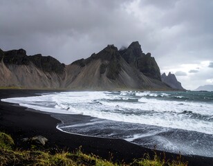 Obraz premium Dramatic black sand beach meeting rugged mountains under a stormy sky