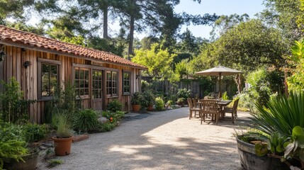Fototapeta premium Quiet garden scene featuring a wooden building and cozy outdoor dining space beneath tall trees