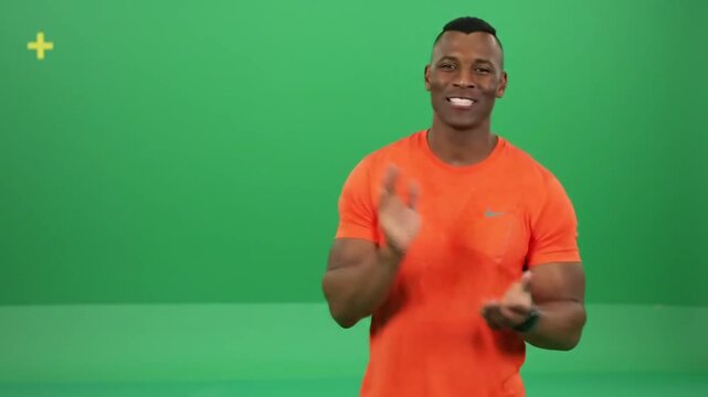Dynamic man clapping hands enthusiastically against vibrant green backdrop, perfect for adding text or graphics, ideal for presentations and promotional content