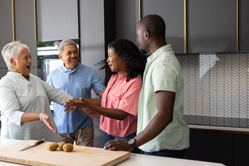 Three generations in kitchen preparing meal, sharing laughter and joyful moments