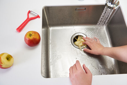 Food waste disposer machine in sink in modern kitchen