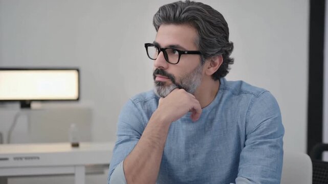 Thoughtful Gaze of Contemplation: A close-up shot of a man with eyeglasses lost in thought, his expression a blend of introspection and contemplation, reflecting deep concentration.