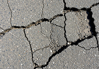 Obraz premium close-up view of severely cracked asphalt pavement