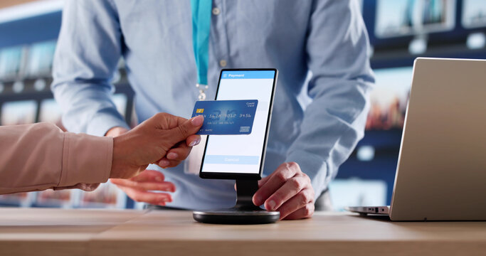 Two People Quickly Complete A Credit Card Transaction At The Counter - Powered by Adobe