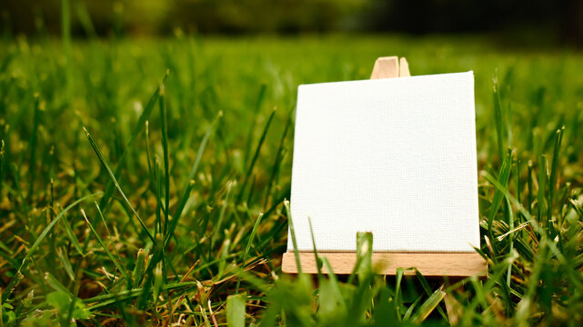 mini easel close up on green grass lawn with copy space
