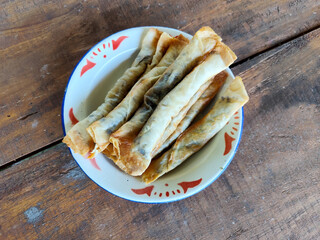 Serving chocolate bananas on an antique iron plate, on a wooden table, menu in a cafe with an outdoor concept.