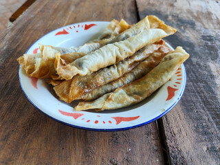 Serving chocolate bananas on an antique iron plate, on a wooden table, menu in a cafe with an outdoor concept.