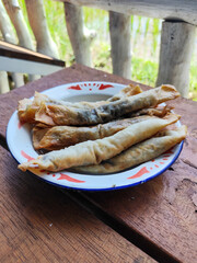 Serving chocolate bananas on an antique iron plate, on a wooden table, menu in a cafe with an outdoor concept.