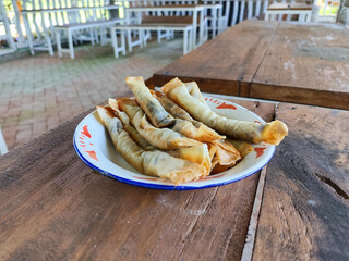 Serving chocolate bananas on an antique iron plate, on a wooden table, menu in a cafe with an outdoor concept.